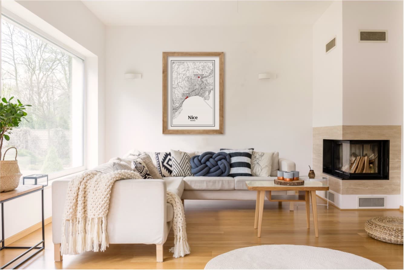 Sala de estar com sofá branco, almofadas e quadro Nice na parede