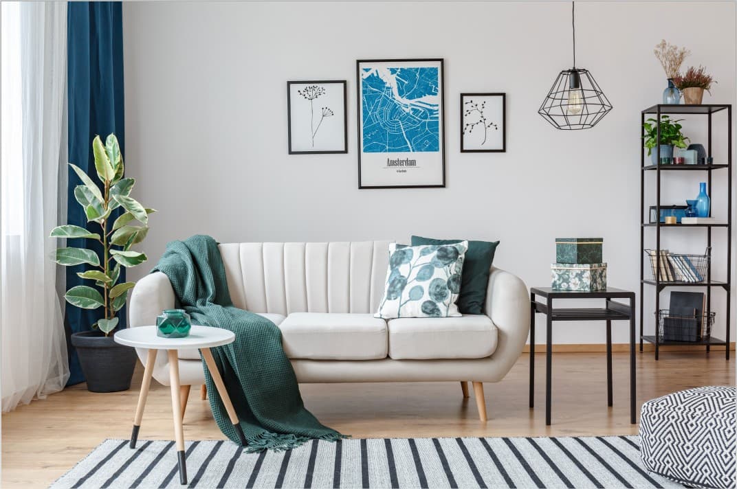 Sala moderna com sofá branco, mesa de centro, tapete riscado e decoração na parede