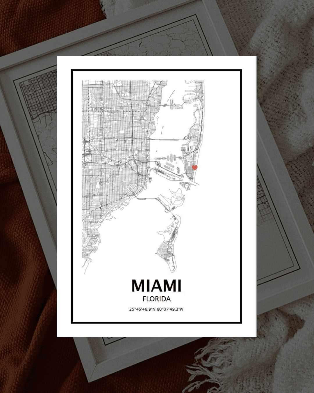 Poster mapa da cidade de Miami em preto e branco emoldurado sobre mantas castanhas e bege